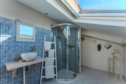 a bathroom with a glass shower and a sink at La Chambre Curry du Bassin in La Teste-de-Buch