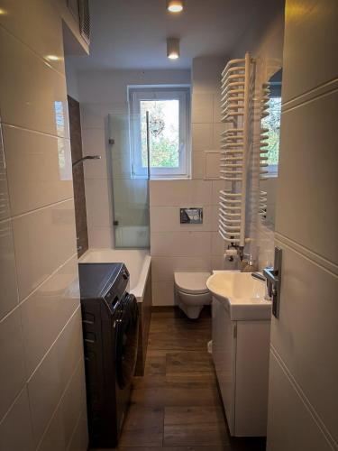 um banheiro com uma pia, uma banheira e um vaso sanitário em Gierymskiego Loft em Gliwice