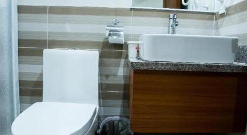 a bathroom with a white toilet and a sink at Hotel Fleur de Liz in Panglao