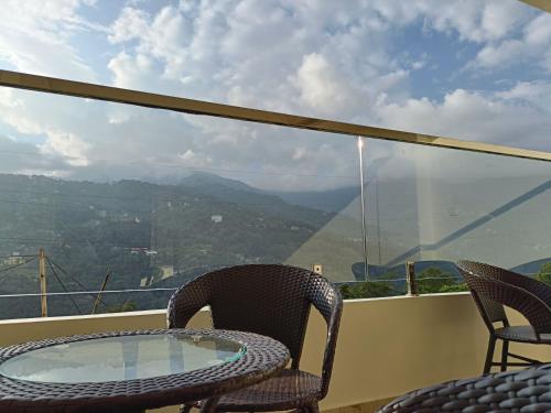 a table and chairs on a balcony with a view at Zambala residency & spa in Gangtok