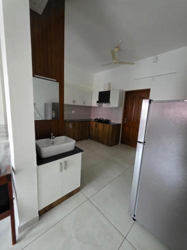 a large bathroom with a sink and a refrigerator at Agarta towers in Perinād