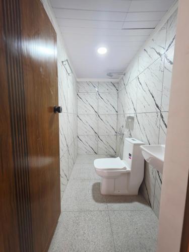 a bathroom with a toilet and a sink at Agarta towers in Perinād