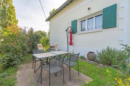 Una mesa y sillas frente a una casa en Gai Réveil - Les Capucines, en La Tremblade
