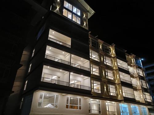 a tall black building with many windows at night at Zambala residency & spa in Gangtok