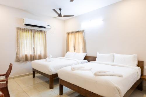 a room with two beds and a chair in it at Blue Mount in Kuilapayam