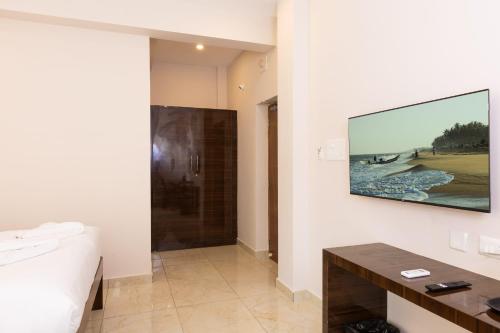 a bathroom with a television hanging on a wall at Blue Mount in Kuilapayam