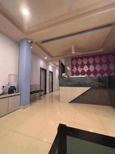 a room with a lobby with purple and white wallpaper at Ashirbad Lodge in Lokpriya Gopinath Bordoloi International