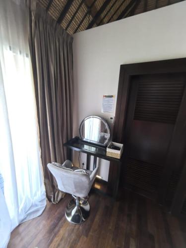 a chair in a room with a table and a window at Goldcoast Palm Tree Sepang Luxury Resort in Sungai Pelik