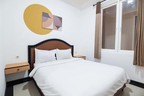 a bedroom with a white bed and a window at Cove Zeidan House in Gabung