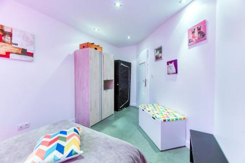 a bedroom with a bed and a refrigerator and a stool at Vacances de rêves - Olympique in Chamrousse