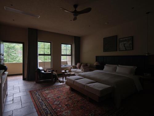 une chambre avec un lit et un salon avec un ventilateur dans l'établissement Jiuzhaigou Valley Scenic and Historic Interest Area Stargazing · Vacilando Resort, à Tazang