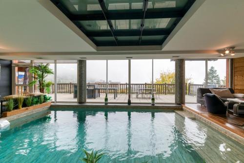 an indoor pool with a view of a house at Vacances de rêves - Olympique in Chamrousse