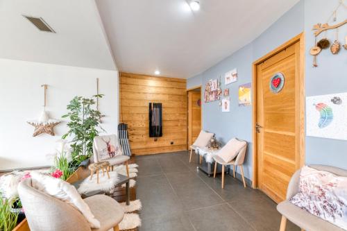 a waiting room with chairs and tables and a tv at Vacances de rêves - Olympique in Chamrousse