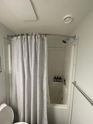 カルガリーにあるThe SuiteLife, Calgaryのシャワーカーテンとトイレ付きのバスルーム