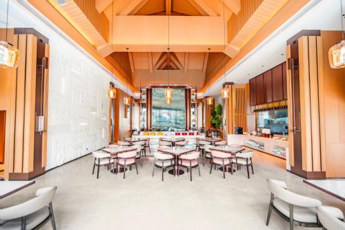 una sala da pranzo con tavoli e sedie e una cucina di Ayutthaya Star Hotel 