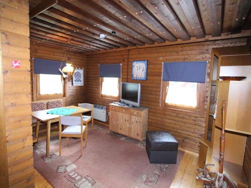 Habitación con mesa y TV en una cabina. en Characterful old farmhouse with 4 apartments in Fresach Carinthia with garden, en Fresach