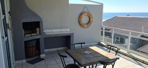 a balcony with a table and chairs and the ocean at Ocean Vibes Studio Apartment in Margate