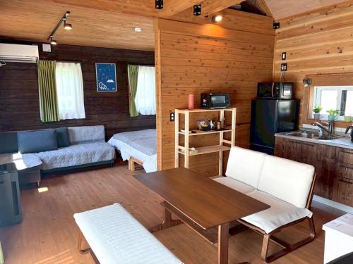 a kitchen and living room with a table and a couch at el green log in Hakuba