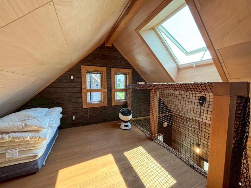 白馬村にあるel green logのベッドと窓が備わる屋根裏部屋