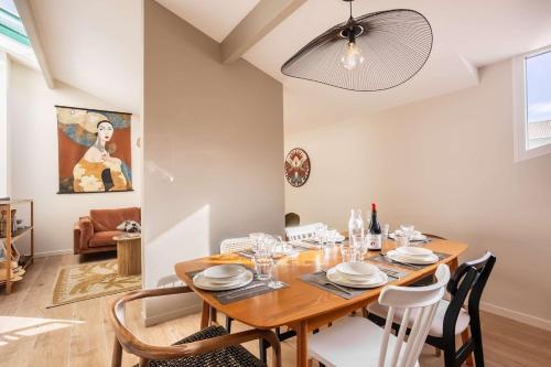 a dining room with a wooden table and chairs at Magnifique Appartement Biscarrosse Bourg in Biscarrosse