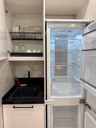 an empty refrigerator with its door open in a kitchen at Nest One Luxe, Элитные апартаменты с балконом и видом на фонтан Tashkent City Park 110 in Tashkent