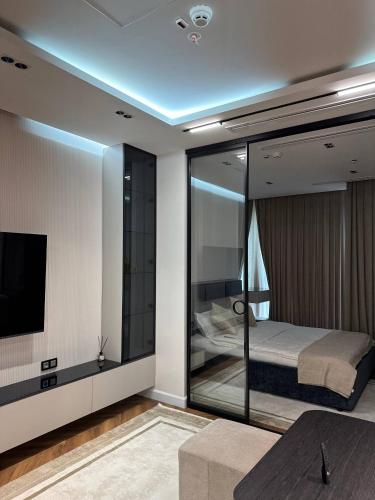 a bedroom with a bed and a tv in it at Nest One Luxe, Элитные апартаменты с балконом и видом на фонтан Tashkent City Park 110 in Tashkent