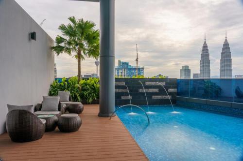 a balcony with a pool and a view of the city at Ikon Service Residence at Eaton in Kuala Lumpur