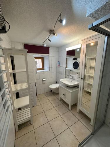 a white bathroom with a sink and a toilet at Bavegna in Parsonz
