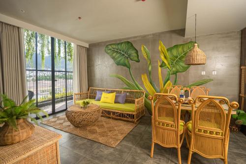 a living room with a couch and a table and chairs at The Signature Hotel Nha Trang in Nha Trang