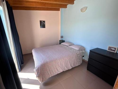 a small bedroom with a bed and a dresser at cavaleiro guest house 800 meters from the sea in Odemira