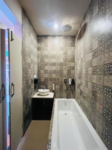 a bathroom with a bath tub and a sink at Artistik Abode by Stay Banaras in Varanasi