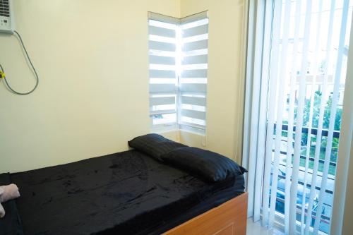 a bed in a room with a large window at Velmiro 514 in Dauis