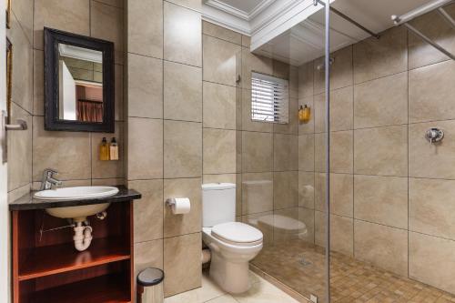 a bathroom with a toilet and a glass shower at Avemore Eikehoff No 26 in Stellenbosch