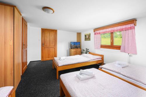 a room with two beds and a window at Penzion pod Ještědem in Světlá pod Ještědem