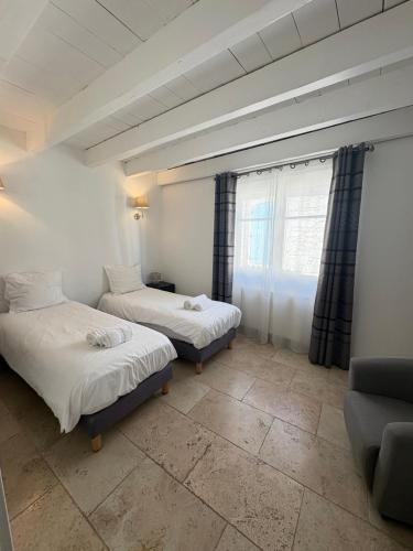 a room with two beds and a couch and a window at Holiday in Arles -Maison du Centre Historique in Arles