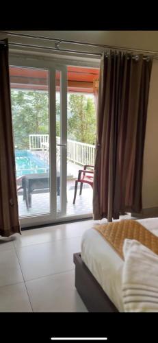 a bedroom with a bed and a view of a patio at The VARANDAH LOUNGE in Vagamon