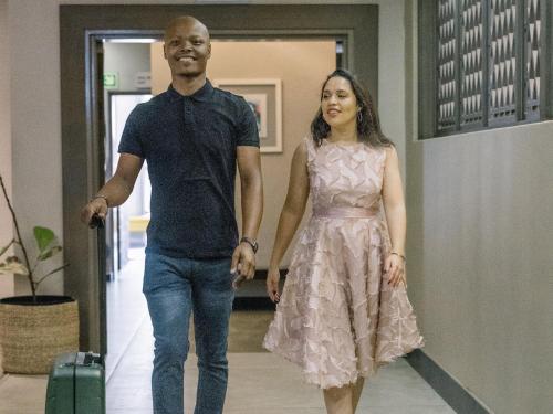 a man and a woman walking down a hallway at ANEW Hotel Hatfield Pretoria in Pretoria