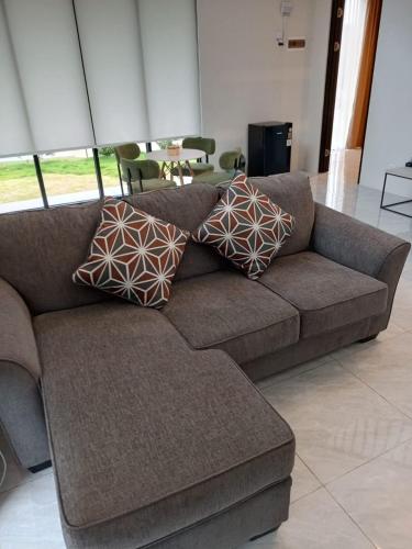 a brown couch with pillows on it in a living room at Wind Hill Mountain View Resort in Gununggeulis