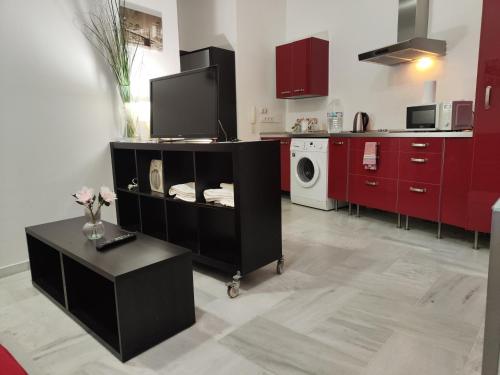 a kitchen with red cabinets and a washer and dryer at jp7 Piso y parking 10min Sevilla - Zona Comercial - Joyeria - Pescaderia in Camas