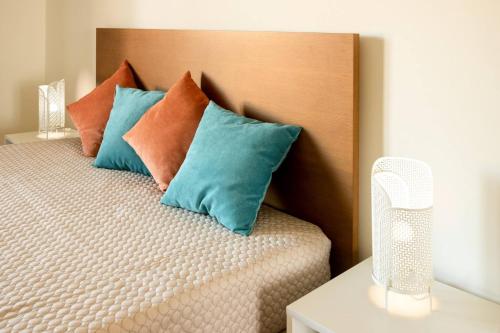a bed with blue and orange pillows on it at Countryside Villa with Nature & Pool - 'Casa dos Vasconcelos' in Chaves