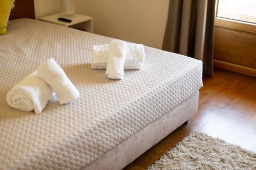 two rolled towels on a bed in a bedroom at Countryside Villa with Nature & Pool - 'Casa dos Vasconcelos' in Chaves