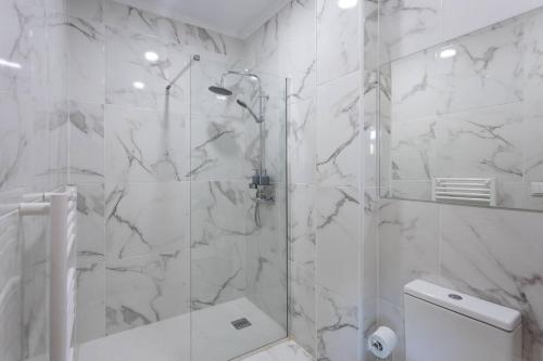 a white bathroom with a shower and a toilet at Countryside Villa with Nature & Pool - 'Casa dos Vasconcelos' in Chaves
