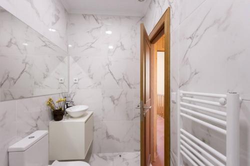 a white bathroom with a toilet and a sink at Countryside Villa with Nature & Pool - 'Casa dos Vasconcelos' in Chaves