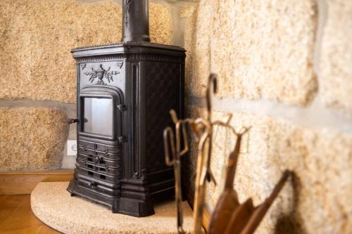 a black stove is sitting in a room at Countryside Villa with Nature & Pool - 'Casa dos Vasconcelos' in Chaves