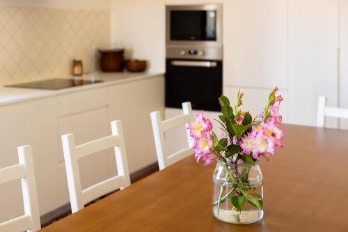 a vase filled with pink flowers sitting on a table at Countryside Villa with Nature & Pool - 'Casa dos Vasconcelos' in Chaves