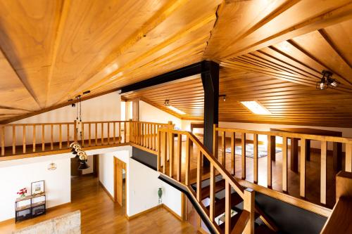an attic room with wooden ceilings and a staircase at Countryside Villa with Nature & Pool - 'Casa dos Vasconcelos' in Chaves