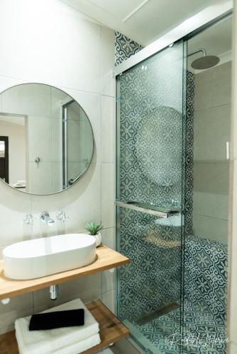 a bathroom with a sink and a glass shower at Karoo Stop Guesthouse in De Aar