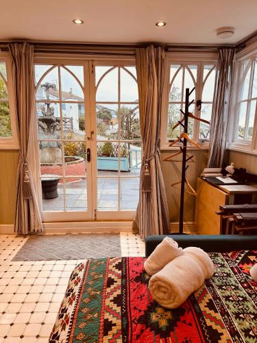 a living room with a bed and a large window at The Little Fountain House in Dawlish
