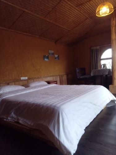 a bedroom with a large white bed in a room at H'mong Cổ Trấn Sapa Homestay & Restaurant in Sa Pa