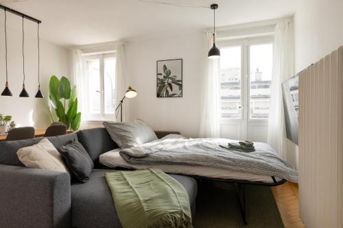 a living room with a couch with a bed on it at Cityview Balcony - in the heart of Biel in Biel